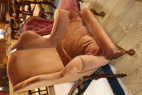 A 1920s upholstered wing armchair